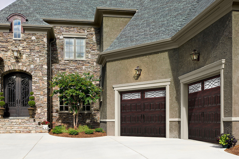 two brown wooden garage doors on a nice southwestern residential home